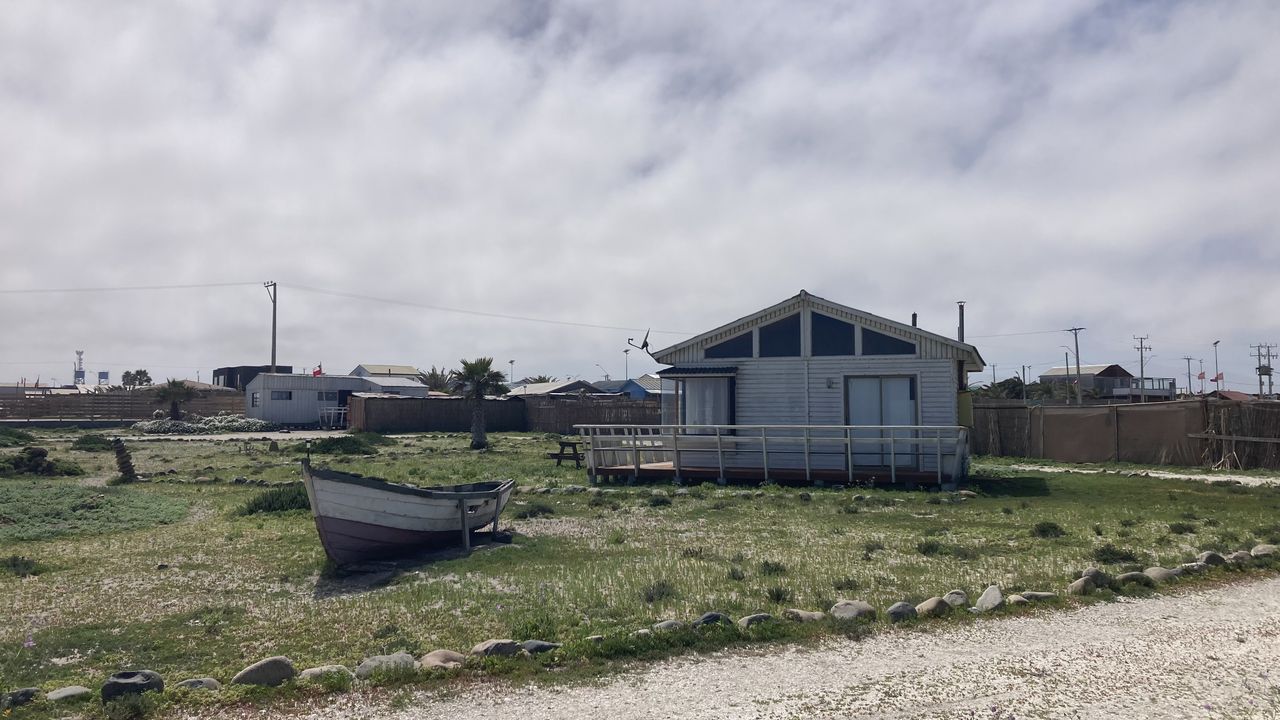 Cabaña con un bote varado en el terreno