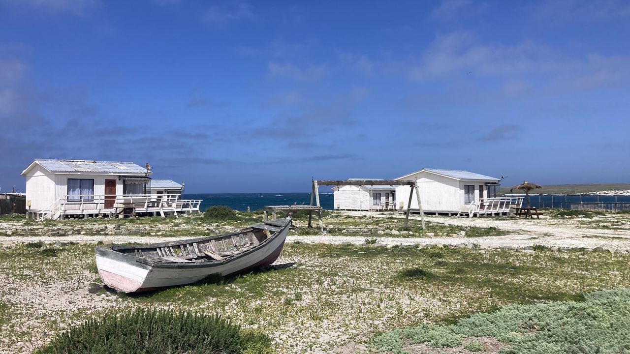 Cabañas del refugio con un bote varado en primer plano
